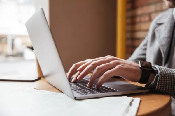 Cropped image of business man sitting by table in cafe